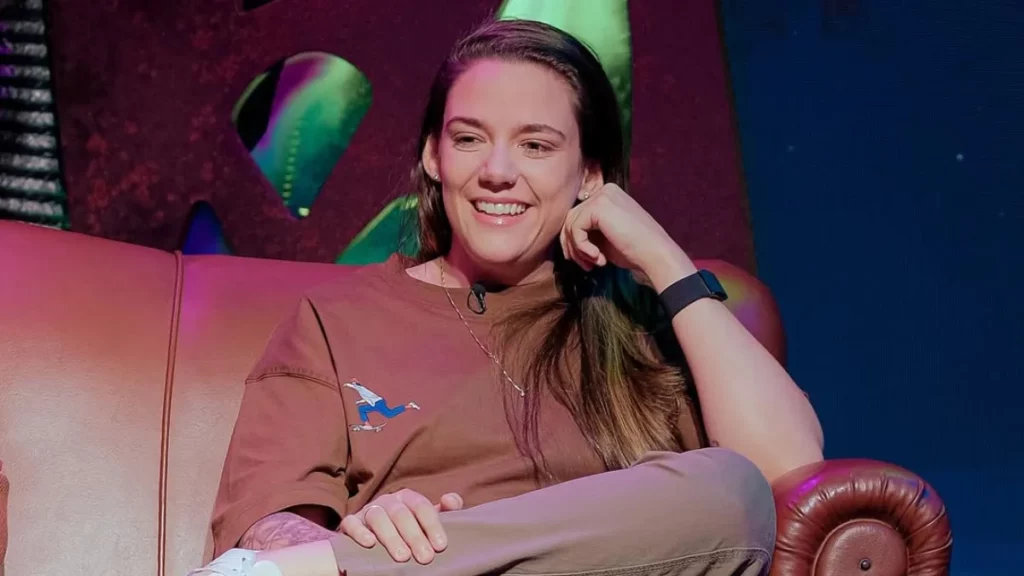 Profissional do mercado gamer sorrindo durante entrevista em ambiente moderno de e-sports