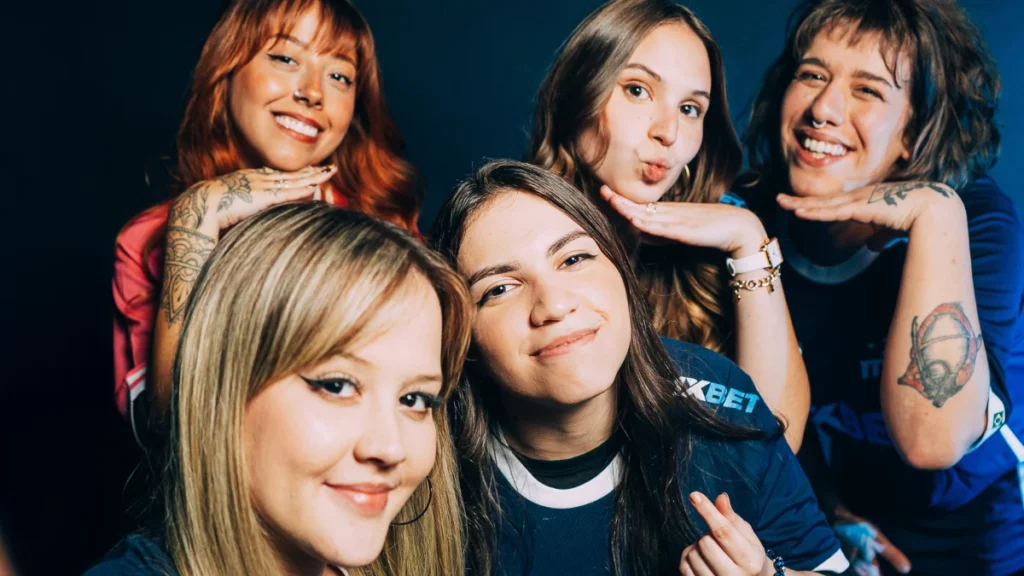 Grupo de mulheres gamers sorrindo juntas durante encontro competitivo da comunidade WIBR.