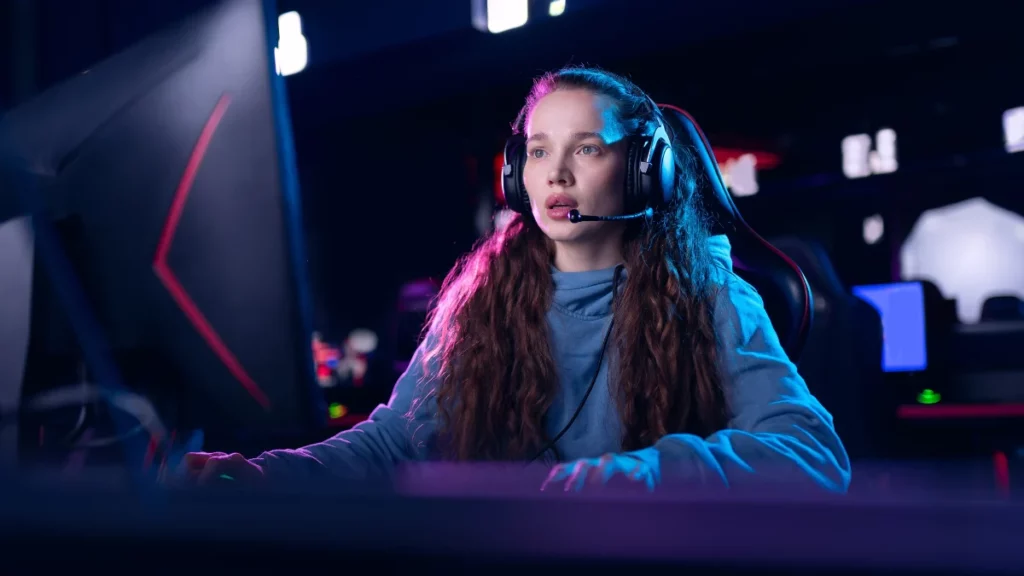 Mulher gamer usando headset em setup iluminado por luzes neon durante partida competitiva